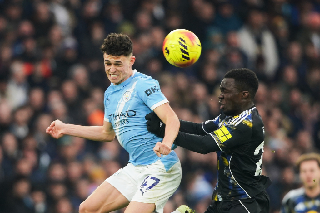 Manchester City's Phil Foden, left, challenges for the ball with Leeds' Wilfried Gnonto during the English Premier League soccer match between Manchester City and Leeds United in Manchester, England, Saturday, Nov. 29, 2025. (AP Photo/Ian Hodgson)