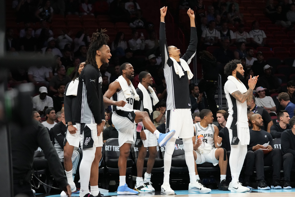 San Antonio Spurs forward Harrison Barnes (40) and forward Victor Wembanyama, second from right, reacts from the bench with their teammates during the second half of an NBA basketball game against the Miami Heat, Monday, March 23, 2026, in Miami. (AP Photo/Lynne Sladky)