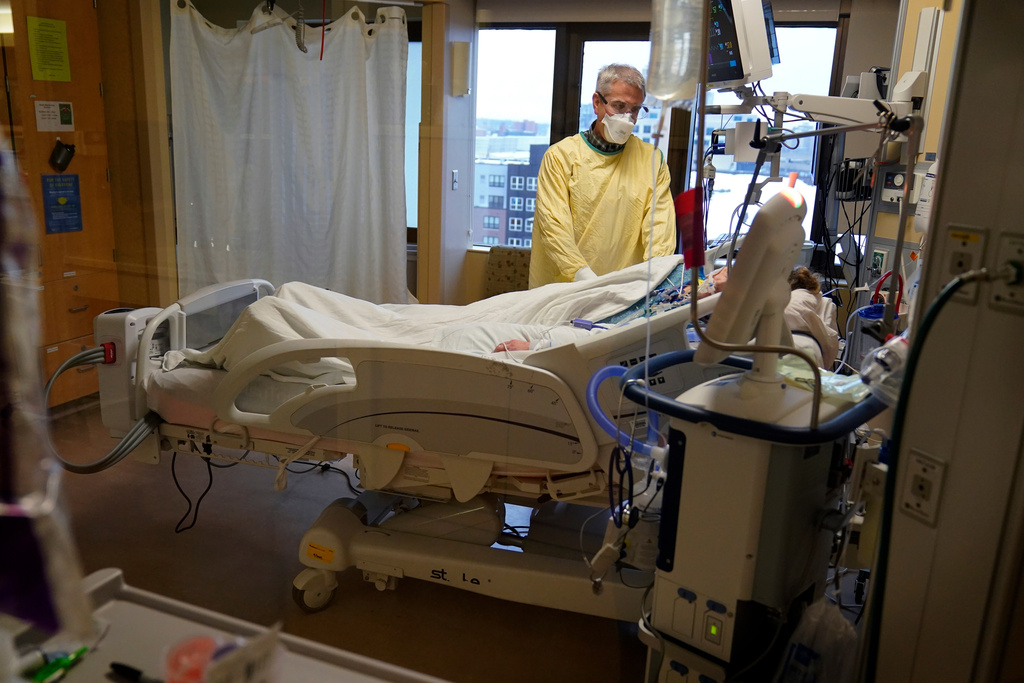 FILE - Steve Grove, a chaplain at Hennepin County Medical Center, prays in a COVID-19 patient's room, Dec. 10, 2021, in Minneapolis. (AP Photo/Charlie Neibergall, File)