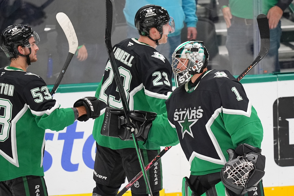 Dallas Stars goaltender Casey DeSmith (1) reacts with center Wyatt Johnston (53) and defenseman Esa Lindell (23) after an overtime win over the Chicago Blackhawks an NHL hockey game Sunday, March 8, 2026, in Dallas. (AP Photo/Julio Cortez)
