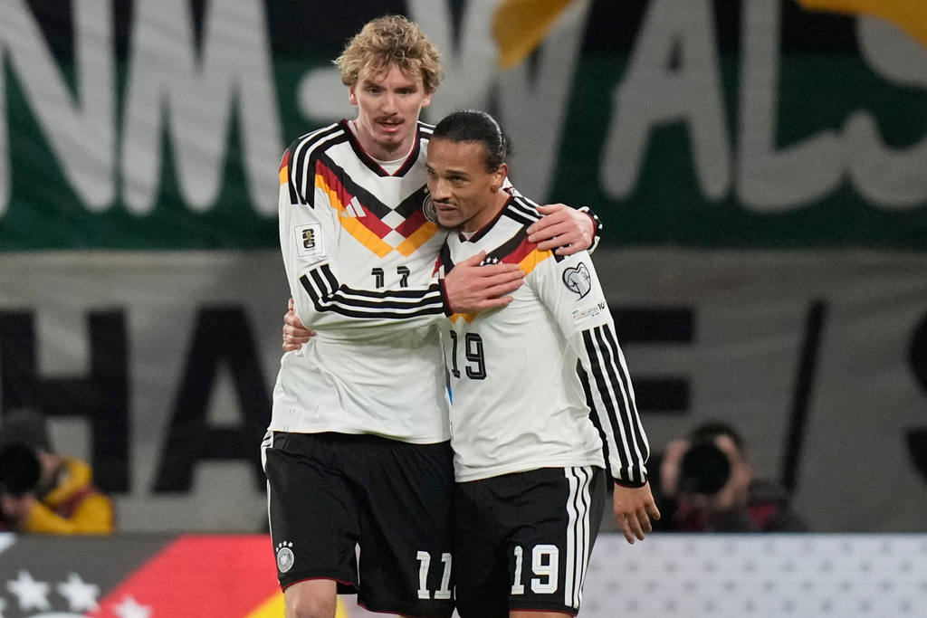 Germany's Nick Woltemade, left, and Leroy Sané hug after scoring during a group A World Cup qualifiying soccer match between Germany and Slovakia in Leipzig, Germany, Monday, Nov. 17, 2025. (AP Photo/Matthias Schrader)