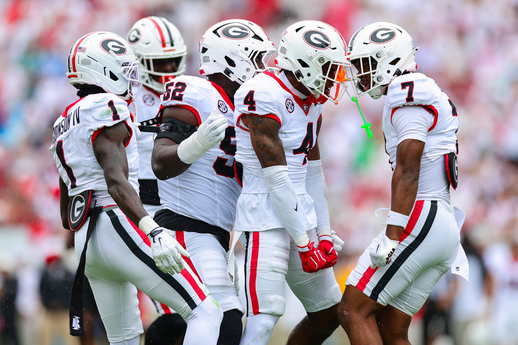 Georgia defensive back KJ Bolden (4) reacts with safety Khalil Barnes (7), defensive back Ellis Robinson IV (1) and Georgia defensive lineman Valdin Sone (52) during the first half of an NCAA college football game against Western Kentucky, Saturday, Sept. 12, 2026, in Athens, Ga. (AP Photo/Colin Hubbard)
