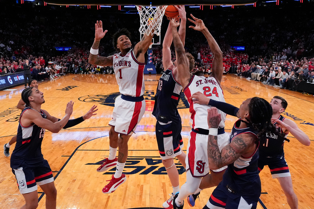 UConn center Eric Reibe (12) is blocked by St. John's forward Dillon Mitchell (1) and St. John's forward Zuby Ejiofor (24) during the first half of an NCAA college basketball game in the championship of the Big East tournament, Saturday, March 14, 2026, in New York. (AP Photo/Yuki Iwamura)