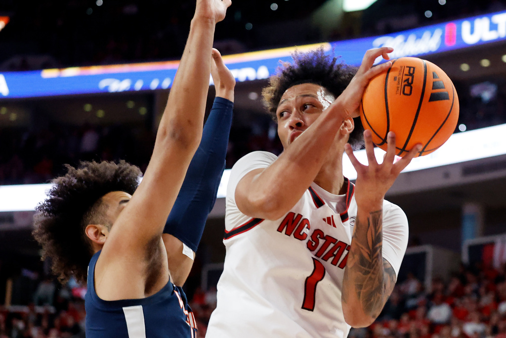 North Carolina State's Darrion Williams (1) tries to pass the ball past Virginia's Malik Thomas (1) during the first half of an NCAA college basketball game in Raleigh, N.C., Saturday, Jan. 3, 2026. (AP Photo/Karl DeBlaker)