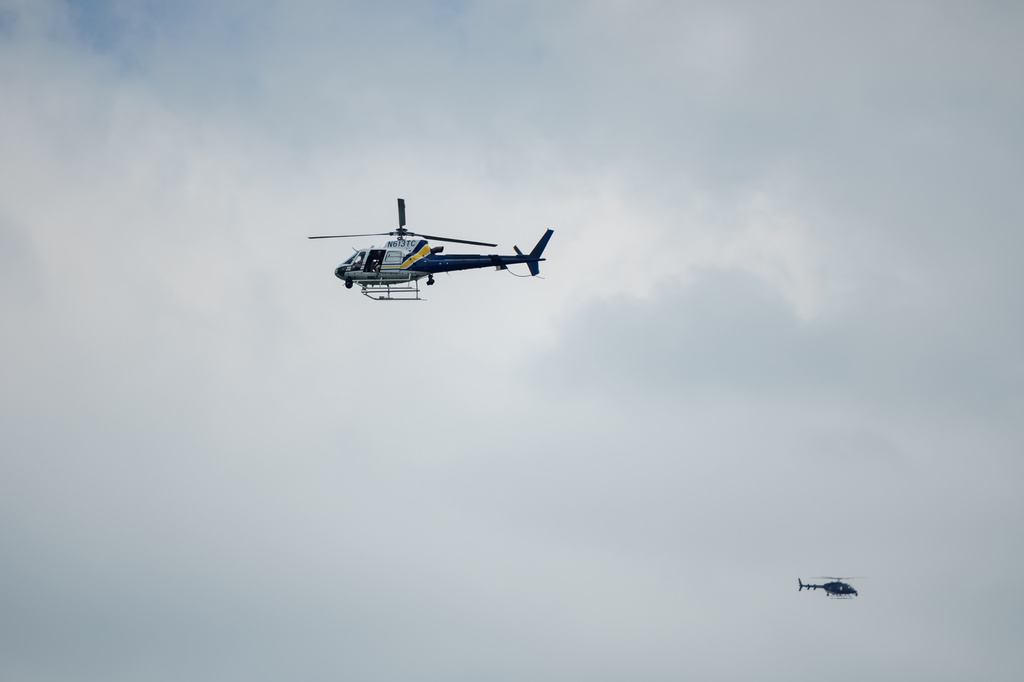 Helicopters fly overhead as law enforcement respond to a shooting at the the Mall of Louisiana, Thursday, April 23, 2026, in Baton Rouge, La. (AP Photo/Matthew Hinton)