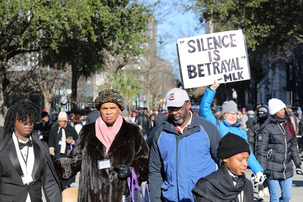 FILE - A marcher holds up a sign at a march and rally at the South Carolina Statehouse to honor Martin Luther King Jr. on his holiday on Monday, Jan. 20, 2025, in Columbia, S.C. (AP Photo/Jeffrey Collins, File)