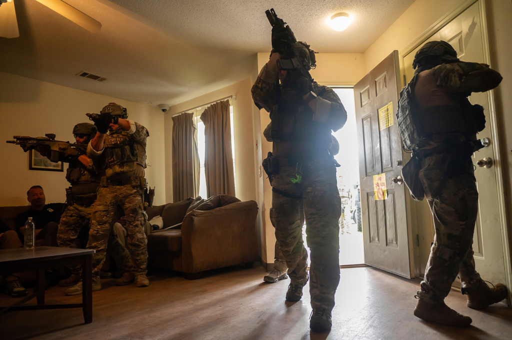 Immigration and Customs Enforcement (ICE) Special Response Team members demonstrate how the team enters a residence in the pursuit of a wanted subject at the Federal Law Enforcement Training Centers (FLETC) in Brunswick, Ga. on Thursday, Aug. 21, 2025. (AP Photo/Fran Ruchalski)
