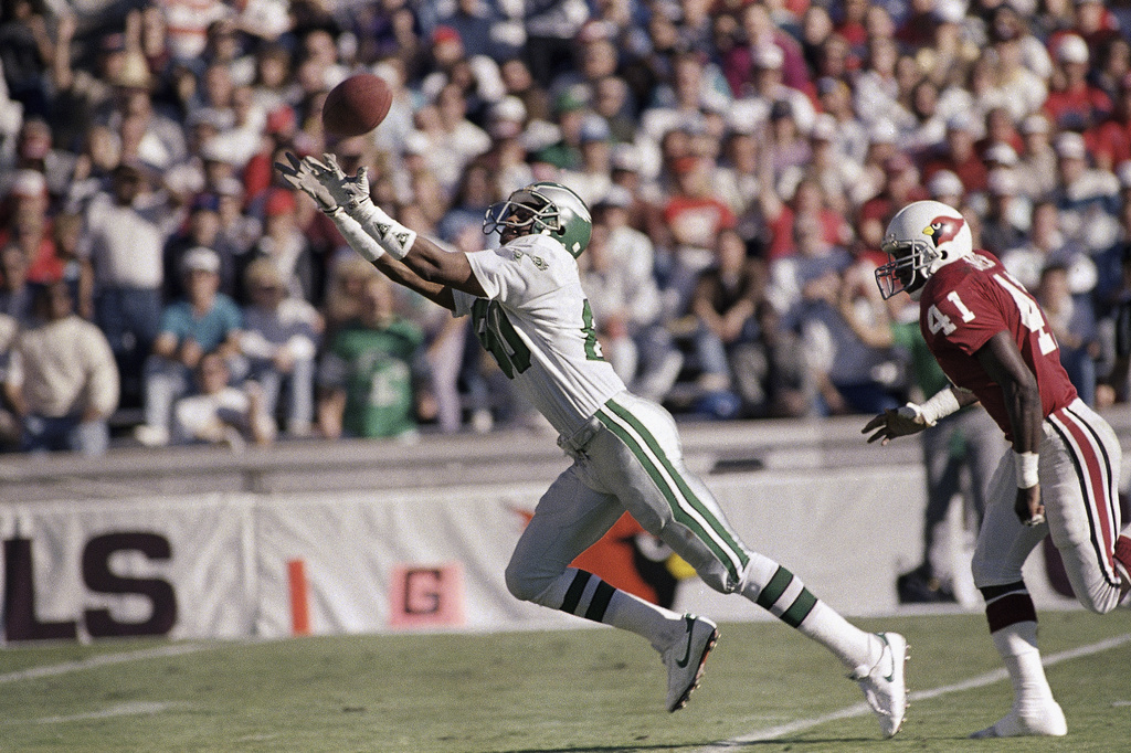 FILE - Philadelphia Eagles wide receiver Cris Carter catches a touchdown pass from quarterback Randall Cunningham during the first quarter of their game in Tempe, Ariz., Dec. 10, 1988, against the Phoenix Cardinals. (AP Photo/Rob Schumacher, File)