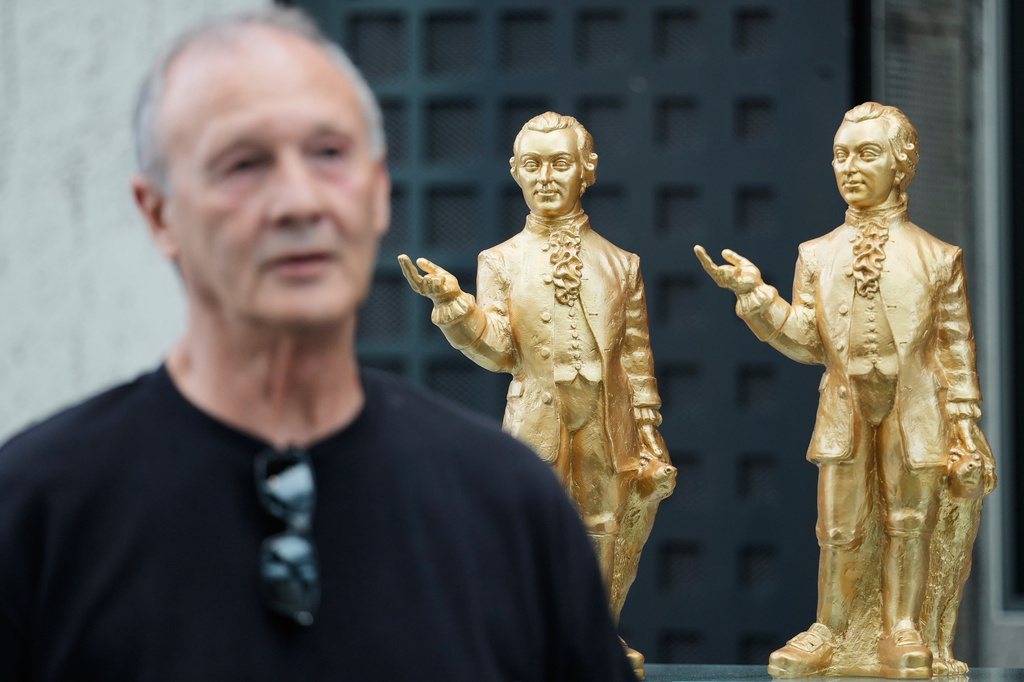 German artist Ottmar Hoerl from Nuremberg talks to journalists at his installation comprising of 400 gold colored plastic Mozart sculptures for the 270th birthday of composer Wolfgang Amadeus Mozart in Salzburg, Austria, Wednesday, July 15, 2026. (AP Photo/Matthias Schrader)