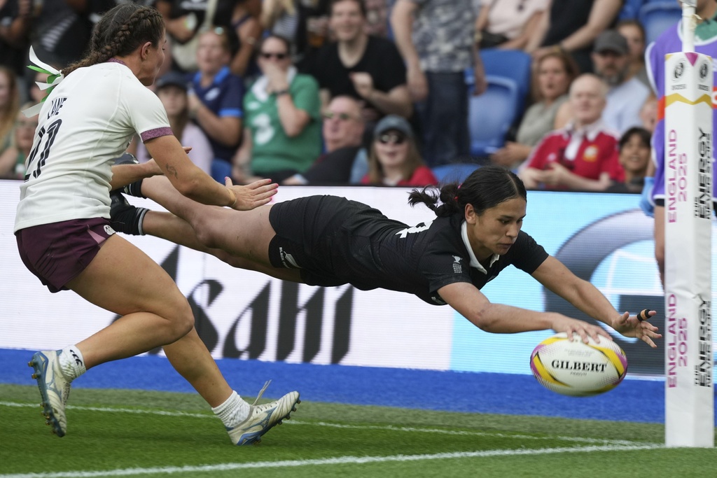 New Zealand's Braxton Sorensen-McGee, right, scores a try as Ireland's Emily Lane tries to defend during the Women's Rugby World Cup 2025 Pool C match between New Zealand and Ireland in Brighton and Hove, England, Sunday, Sept. 7, 2025. (AP Photo/Alastair Grant)