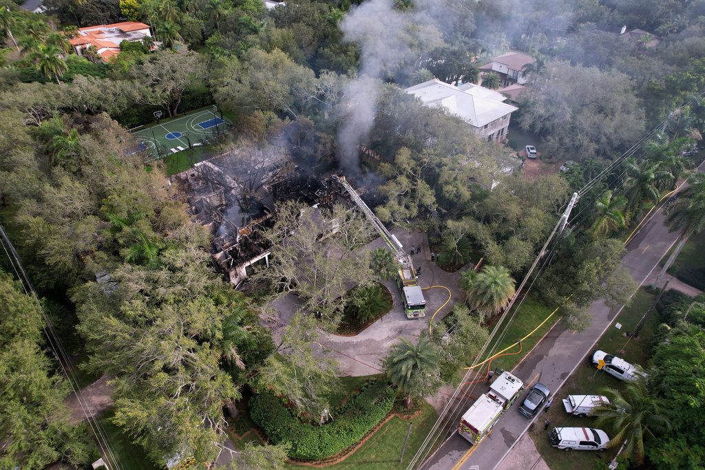 Firefighters work to extinguish the remains of a fire at a home owned by Miami Heat basketball coach Erik Spoelstra, Thursday, Nov. 6, 2025, in Miami. (AP Photo/Rebecca Blackwell)