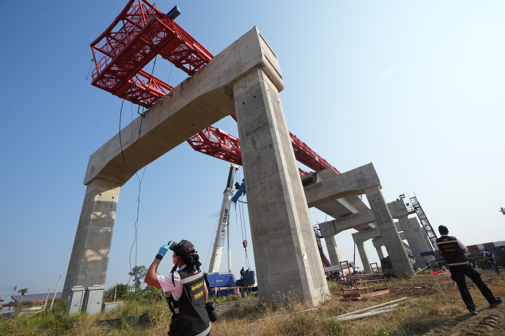 Forensic workers inspect the train accident site, a day after a construction crane fell into a passenger train in Nakhon Ratchasima province, Thailand, Thursday, Jan. 15, 2026. (AP Photo/Sakchai Lalit)
