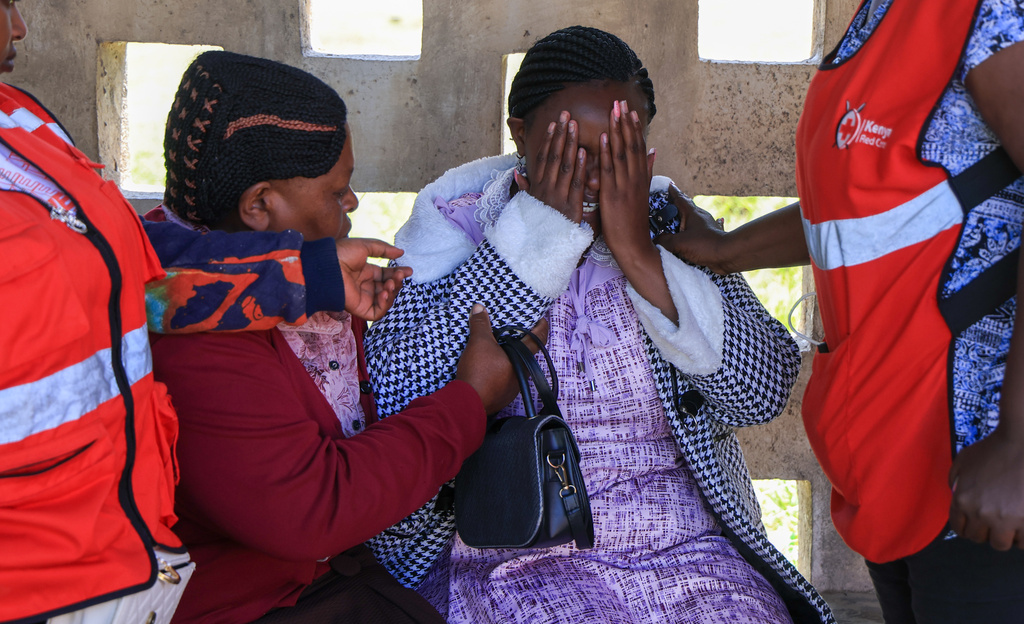A parent of a victim of the fire at the Utumishi Girls Academy is consoled ahead of body identification and DNA testing at Naivasha Funeral Home in Naivasha Town, Rift Valley region, Kenya, Friday, May 29, 2026. (AP Photo/Andrew Kasuku)