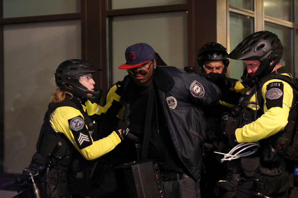 Portland Police detain a protestor outside a U.S. Immigration and Customs Enforcement facility in Portland, Oregon, Friday, Oct. 3, 2025. (AP Photo/Amanda Loman)