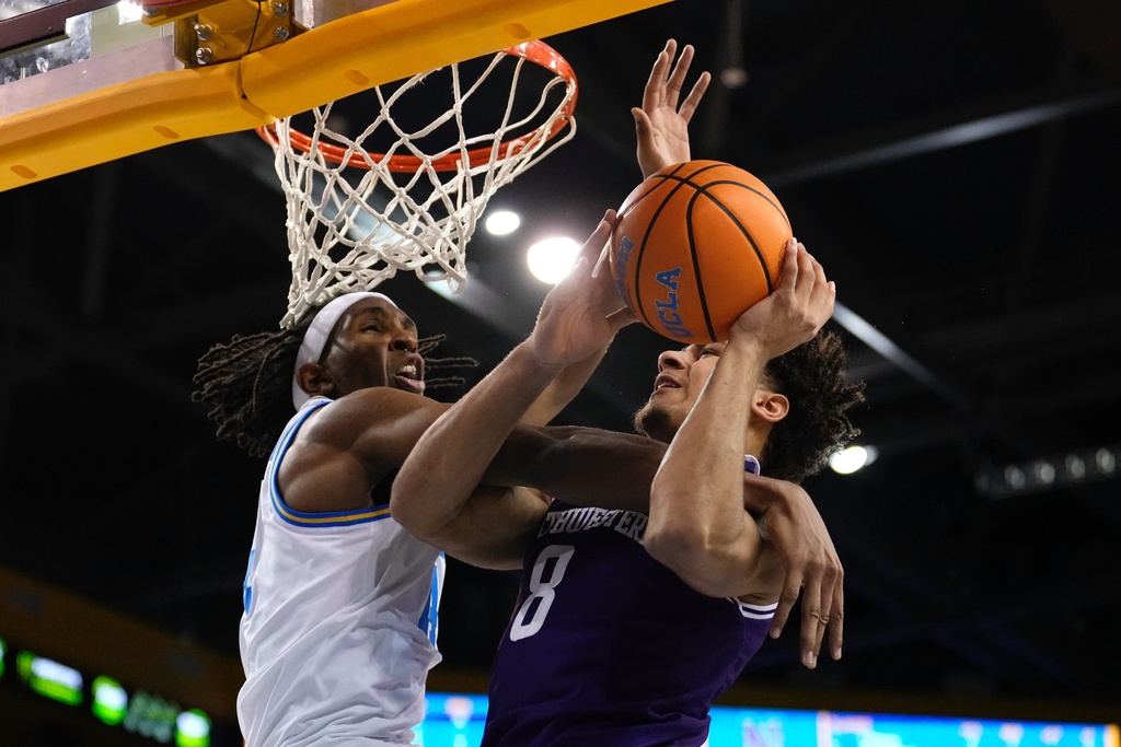 Northwestern forward Tre Singleton, right, tries to shoot as UCLA forward Steven Jamerson II defends during the first half of an NCAA college basketball game Saturday, Jan. 24, 2026, in Los Angeles. (AP Photo/Mark J. Terrill)