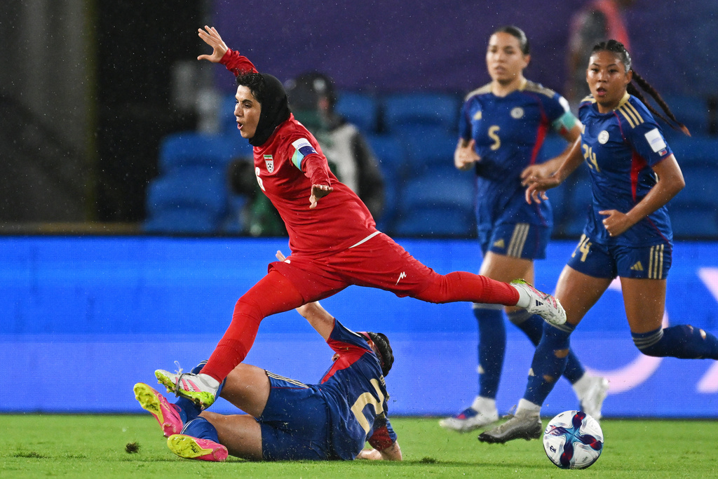 Iran's Zahra Sarbali, top, and Philippines' Malea Cesar battle for the ball during the Women's Asian Cup soccer match between Iran and the Philippines in Robina, Australia, Sunday, March 8, 2026. (Dave Hunt/AAP Image via AP)