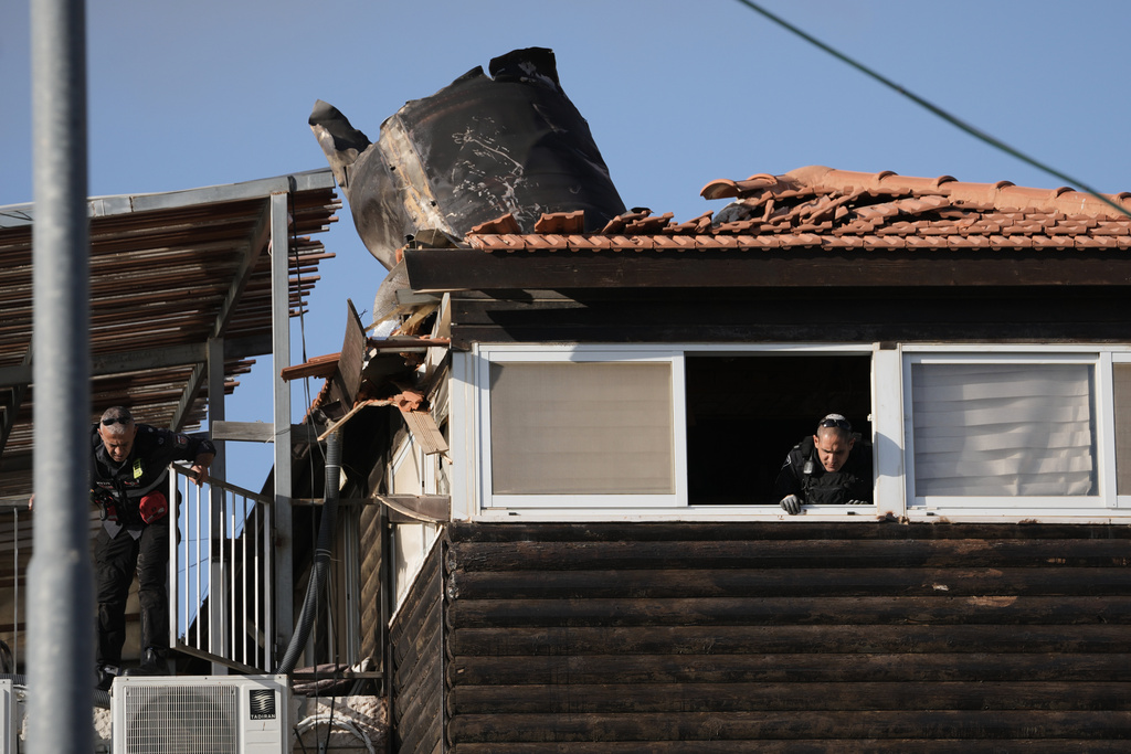 Israeli security forces inspect a house in east Jerusalem where a fragment of an Iranian missile crashed onto the rooftop, Monday, March 16, 2026. (AP Photo/Mahmoud Illean)