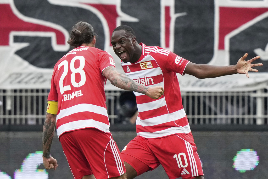 Union's Ilyas Ansah, right, celebrates with Union's Christopher Trimmel after scoring the opening goal during the German Bundesliga soccer match between FC Union Berlin and VfB Stuttgart, at the An der Alten Forsterei stadium in Berlin, Germany, Saturday, Aug. 23, 2025. (AP Photo/Ebrahim Noroozi)