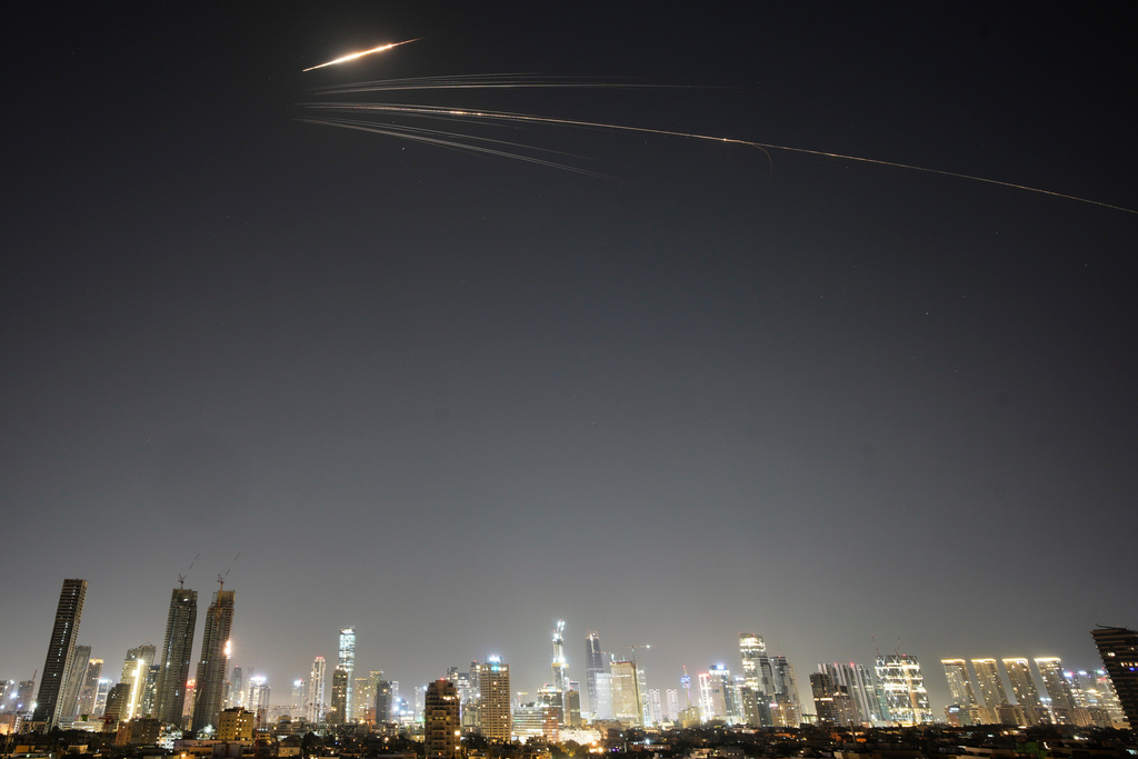 Missiles launched from Iran streak across the sky over central Israel, Wednesday, March 18, 2026. (AP Photo/Ohad Zwigenberg)