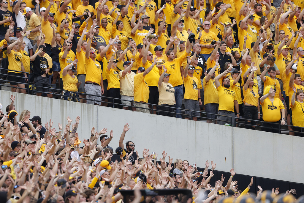 FILE - Iowa fans wave to children in the University of Iowa Stead Family Children's Hospital at the end of the first quarter of an NCAA college football game between Iowa and Penn State, Oct. 9, 2021, in Iowa City, Iowa. (AP Photo/Matthew Putney, File)