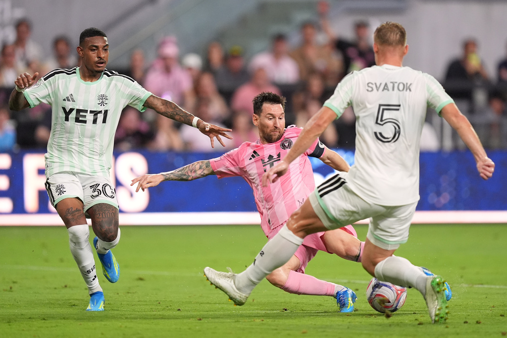 Inter Miami forward Lionel Messi (10) shoots past Austin FC midfielder Joseph Rosales (30) and defender Oleksandr Svatok (5) during the first half of an MLS soccer match, Saturday, April 4, 2026, in Miami. (AP Photo/Rebecca Blackwell)