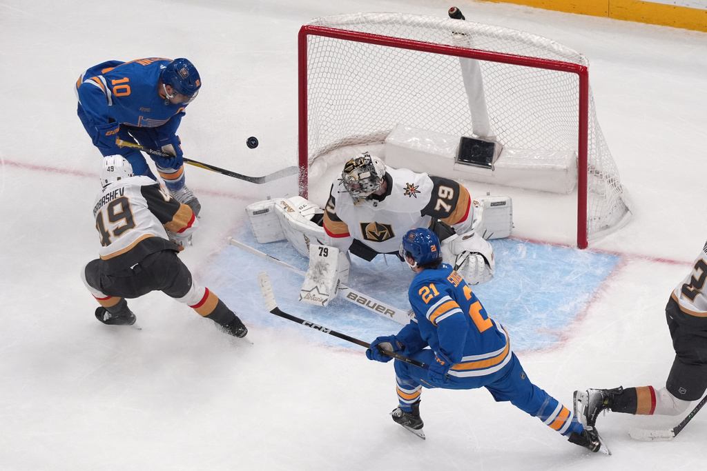 St. Louis Blues' Brayden Schenn (10) scores past Vegas Golden Knights goaltender Carter Hart (79) and Ivan Barbashev (49) as teammate Jimmy Snuggerud (21) watches during the third period of an NHL hockey game Friday, Jan. 2, 2026, in St. Louis. (AP Photo/Jeff Roberson)