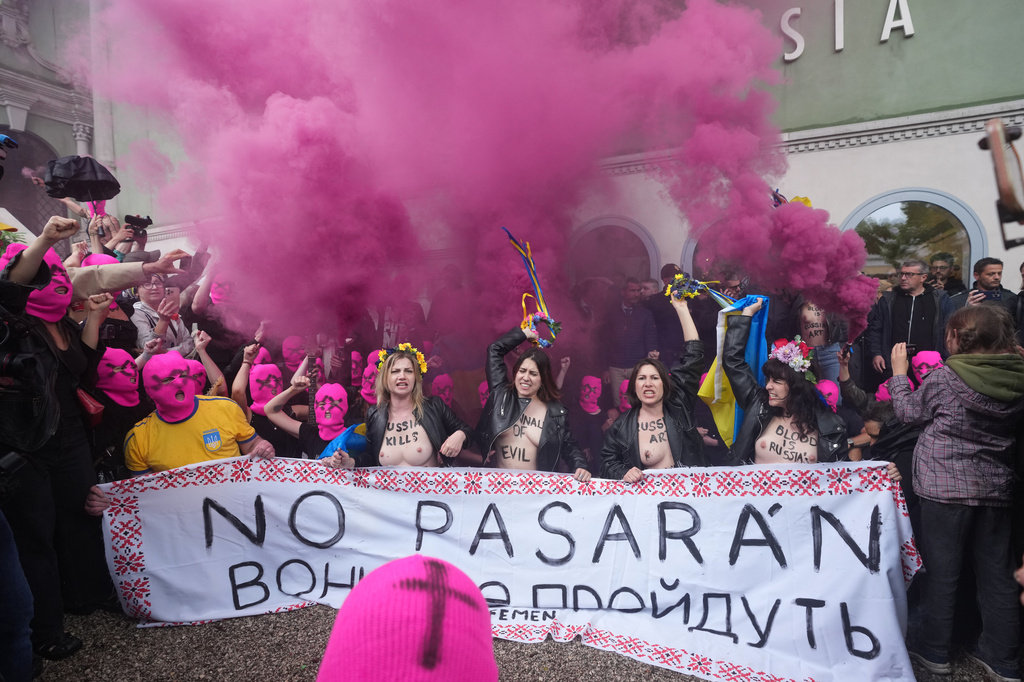 EDS NOTE: NUDITY - Pussy Riot and FEMEN activists stage a protest against Russia's presence after its absence following the 2022 invasion of Ukraine in front of the Russian pavilion, at the 2026 Art Venice Biennale, in Venice, Italy, Wednesday, May 6, 2026. Writing on banner partially reads in Ukrainian "God... will pass"(AP Photo/Luca Bruno)