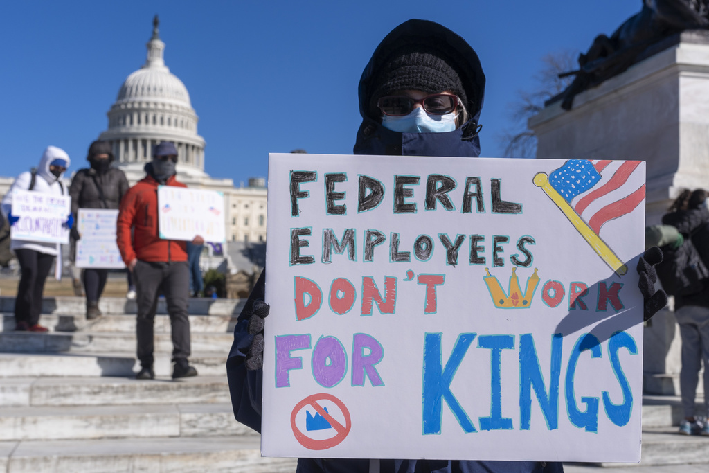 FILE - A federal employee, who asked not to use their name for fears over losing their job, protests with a sign saying &quot;Federal Employees Don't Work for Kings&quot; during the &quot;No Kings Day&quot; protest on Presidents Day , Feb. 17, 2025, near the Capitol in Washington. (AP Photo/Jacquelyn Martin, File)