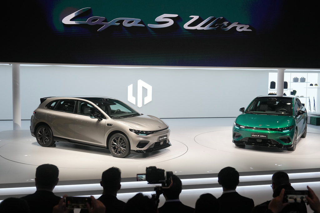 Attendees look at the Leapmotor new Lafa 5 Ultra models on stage after being unveiled by Leapmotor President Cao Li at the Auto China 2026, in Beijing, Friday, April 24, 2026. (AP Photo/Andy Wong)