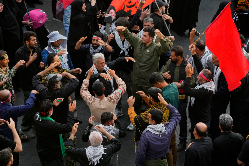 Mourners chant and perform mourning rituals as they make their way to the funeral procession of the slain Iranian Supreme Leader Ayatollah Ali Khamenei in Tehran, Iran, Monday, July 6, 2026. (AP Photo/Vahid Salemi)