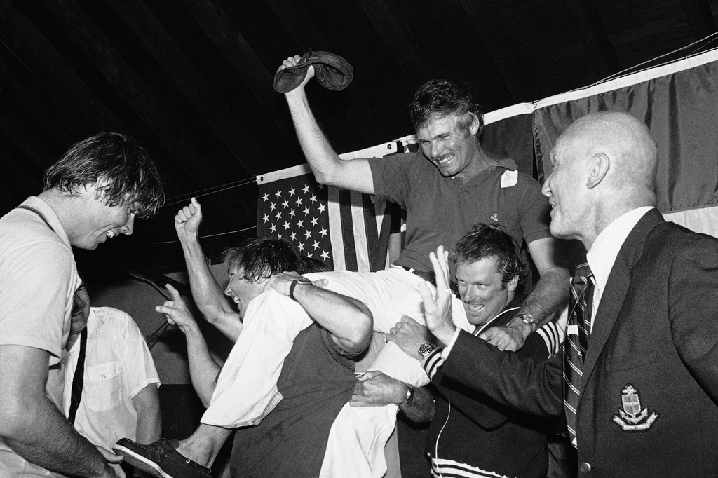 FILE - Ted Turner, center, is carried off by his crew following a news conference after his vessel Courageous won the Americas Cup sailing race, Sept. 19, 1977, in Newport, R.I. At right is Bill Ficker, skipper of cup winner Intrepid in 1970. (AP Photo/J. Walter Green, File)