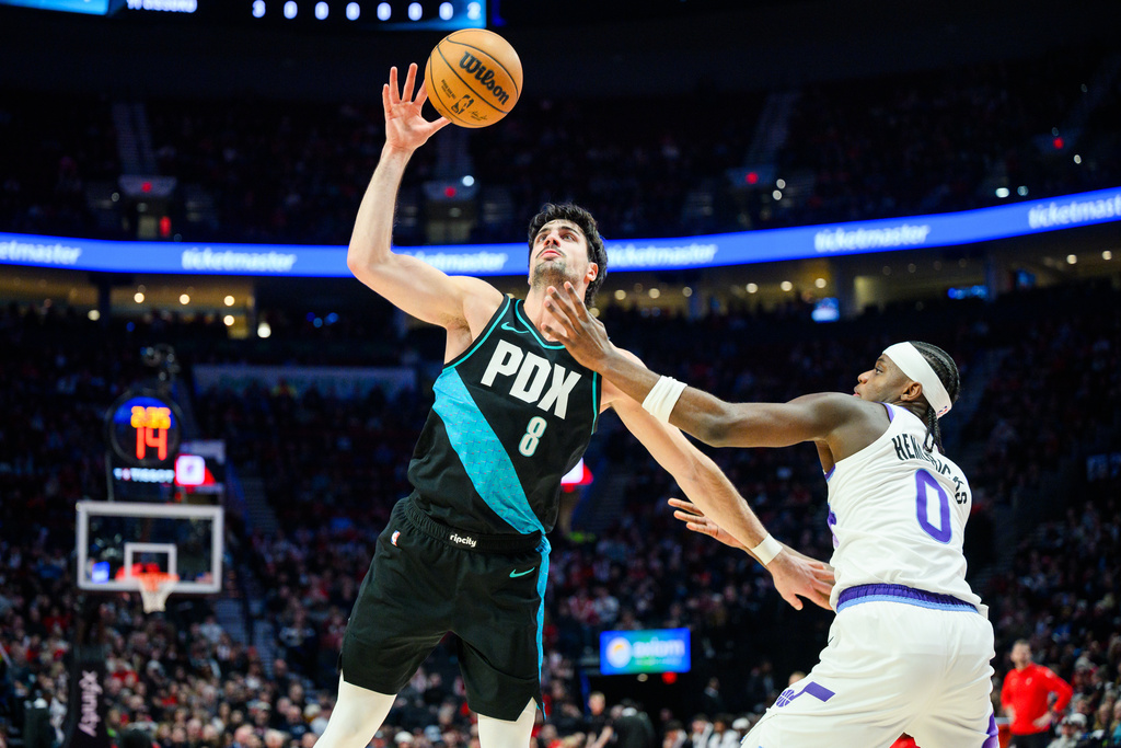 Portland Trail Blazers forward Deni Avdija (8) grabs control of the ball over Utah Jazz forward Taylor Hendricks (0) during the first half of an NBA basketball game, Monday, Jan. 5, 2026, in Portland, Ore. (AP Photo/Molly J. Smith)