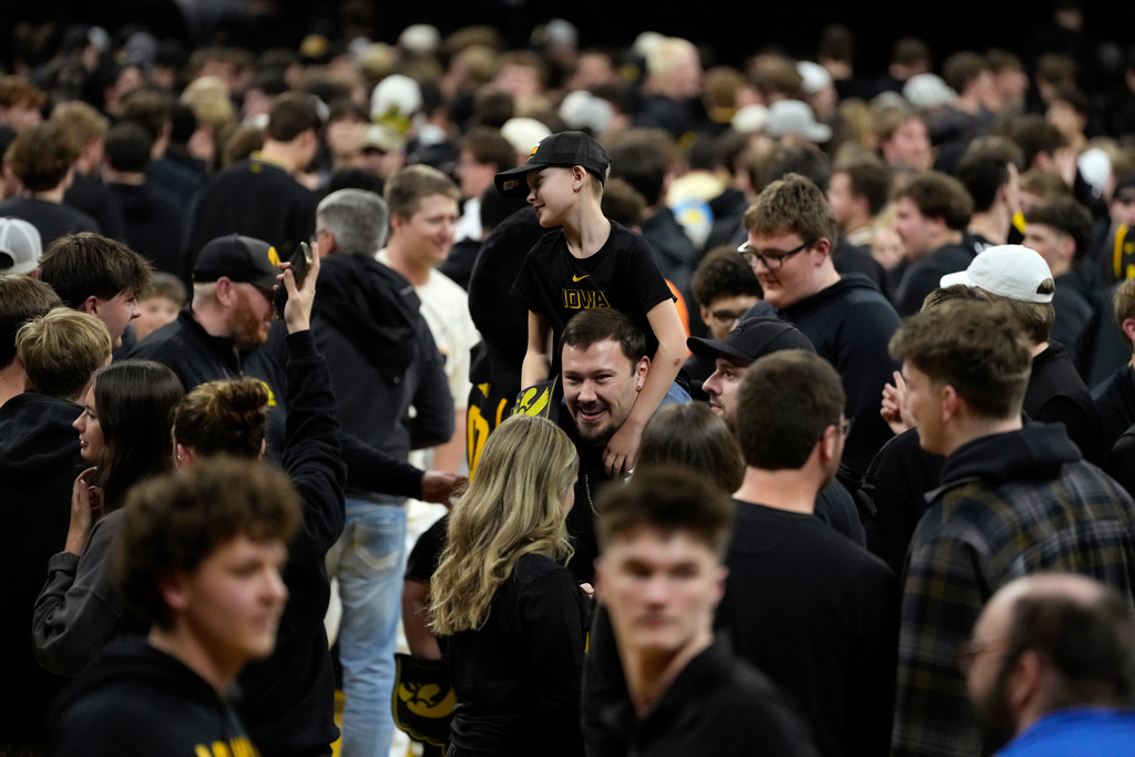 Iowa fans celebrate on the court after an NCAA college basketball game against Nebraska, Tuesday, Feb. 17, 2026, in Iowa City, Iowa. (AP Photo/Charlie Neibergall)