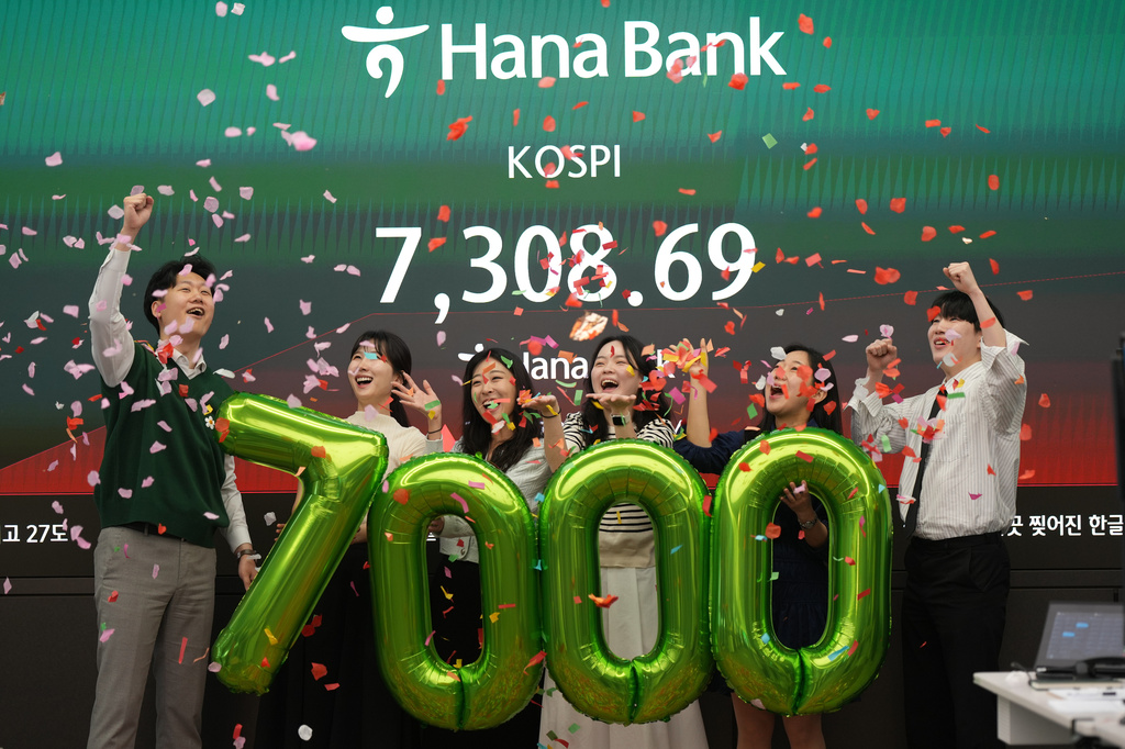 Employees of Hana Bank celebrate in a photo opportunity to mark the Korea Composite Stock Price Index (KOSPI) of over 7,000 points at a dealing room of Hana Bank in Seoul, South Korea, Wednesday, May 6, 2026. (AP Photo/Lee Jin-man)