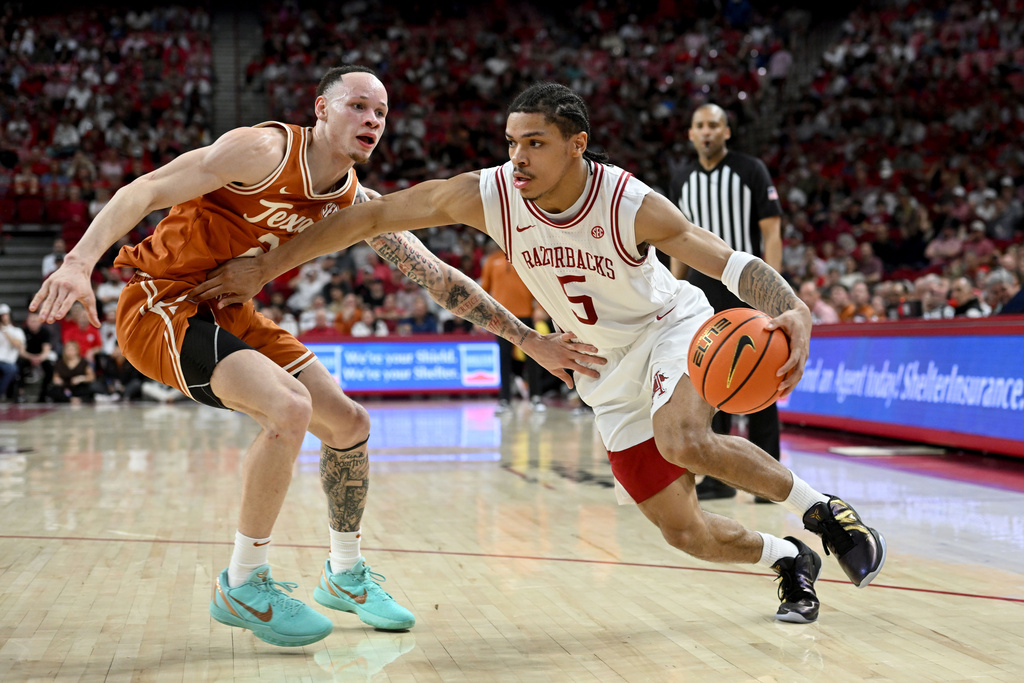 Arkansas guard Darius Acuff Jr. (5) tries to drive past Texas guard Chendall Weaver during the second half of an NCAA college basketball game, Wednesday, March 4, 2026, in Fayetteville, Ark. (AP Photo/Michael Woods)