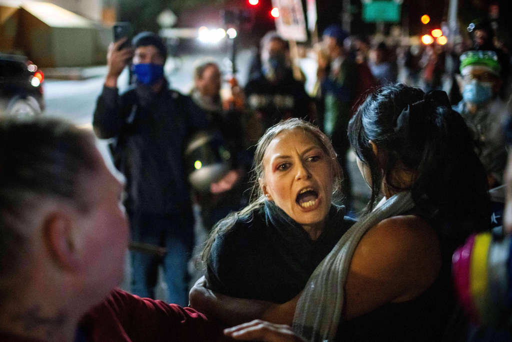 A protester yells at police and federal officers during a protest at a U.S. Immigration and Customs Enforcement facility in Portland, Ore. on Sunday, Oct. 5, 2025. (AP Photo/Ethan Swope)