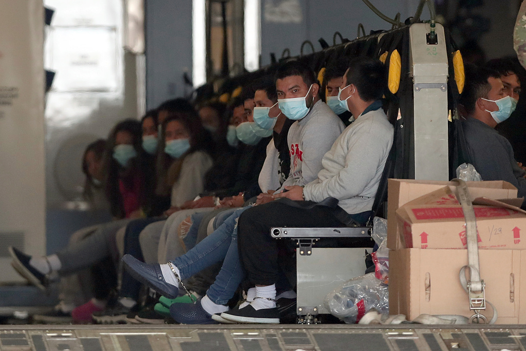FILE - Migrants wearing face masks and shackles on their hands and feet sit on a military aircraft at Fort Bliss in El Paso, Texas, Jan. 30, 2025, awaiting their deportation to Guatemala. (AP Photo/Christian Chavez, File)