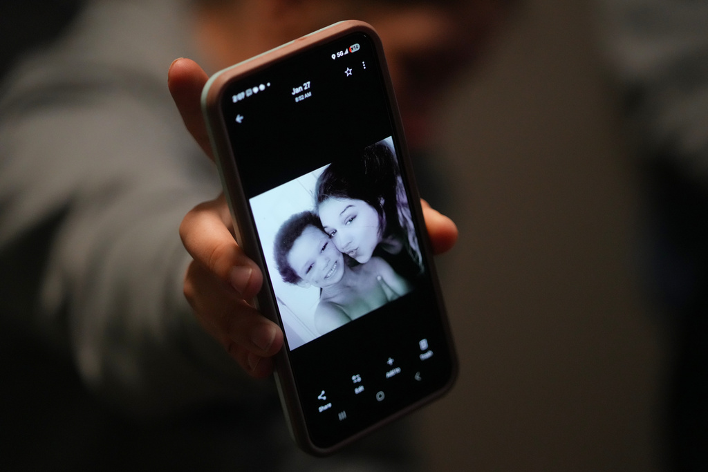 Cheyenne Hangaman shows a photograph of her and her son, Howard, 6, who along with his two brothers Kaleb, 8, and EJ, 9, drowned in a frozen pond Tuesday, Jan. 27, 2026, in Bonham, Texas. (AP Photo/Julio Cortez)