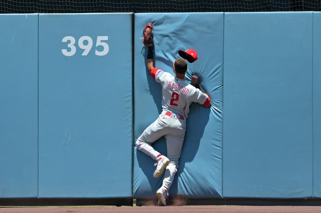 Philadelphia Phillies center fielder Justin Crawford crashes into the wall after making a leaping catch of a ball hit by Los Angeles Dodgers' Andy Pages during the first inning of a baseball game Sunday, May 31, 2026, in Los Angeles. (AP Photo/Jayne Kamin-Oncea)