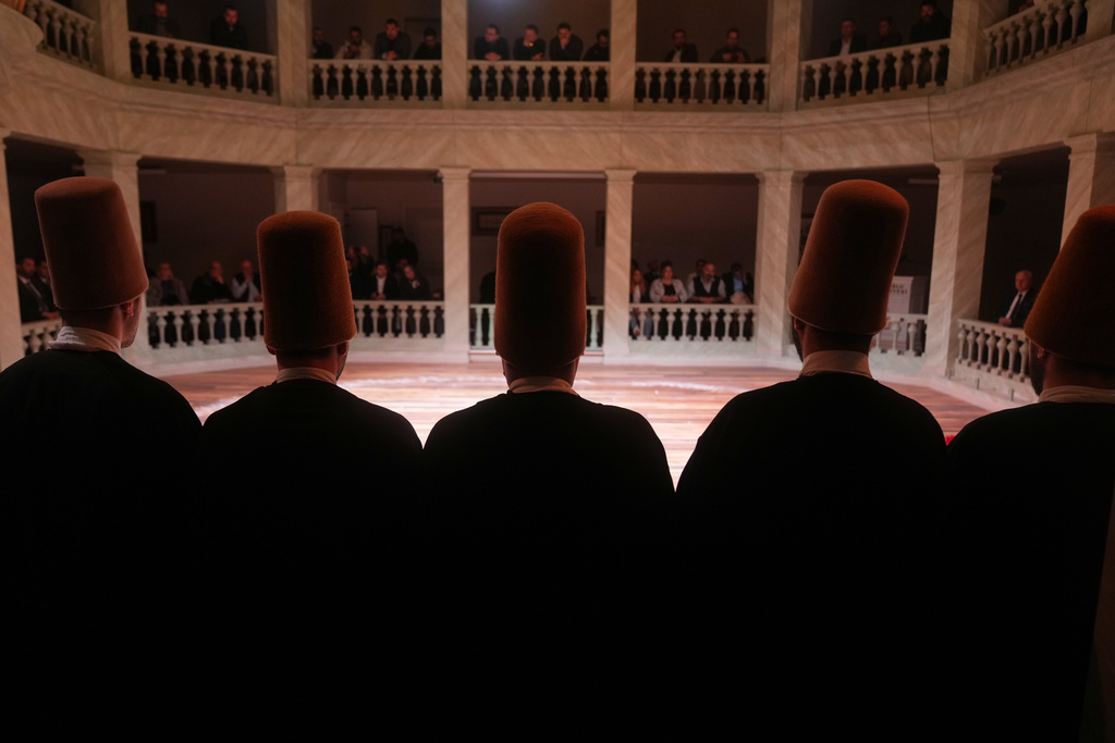CORRECTS YEAR TO 2025 - Whirling dervishes of the Mevlevi order perform during a Sheb-i Arus ceremony at Kasimpasa Mevlevihane in Istanbul, Turkey, Thursday, Dec. 11, 2025, to commemorate the death of 13th century Islamic scholar, poet and Sufi mystic Jalaladdin Rumi. (AP Photo/Francisco Seco)