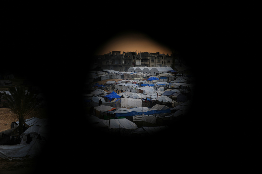 Seen from a building heavily damaged during the Israeli air and ground operations, tents fill a makeshift camp for displaced Palestinians in Deir al-Balah, central Gaza Strip, Saturday, Dec. 13, 2025. (AP Photo/Abdel Kareem Hana)
