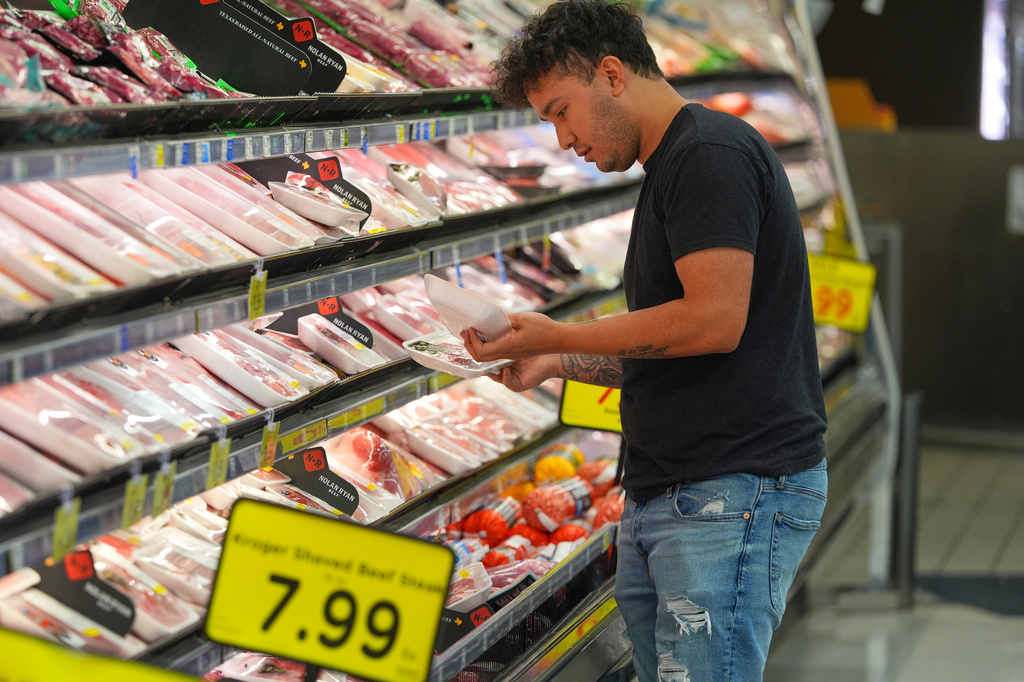 A shopper looks at packages of meat at a grocery store in Dallas, Wednesday, April 15, 2026. (AP Photo/LM Otero)