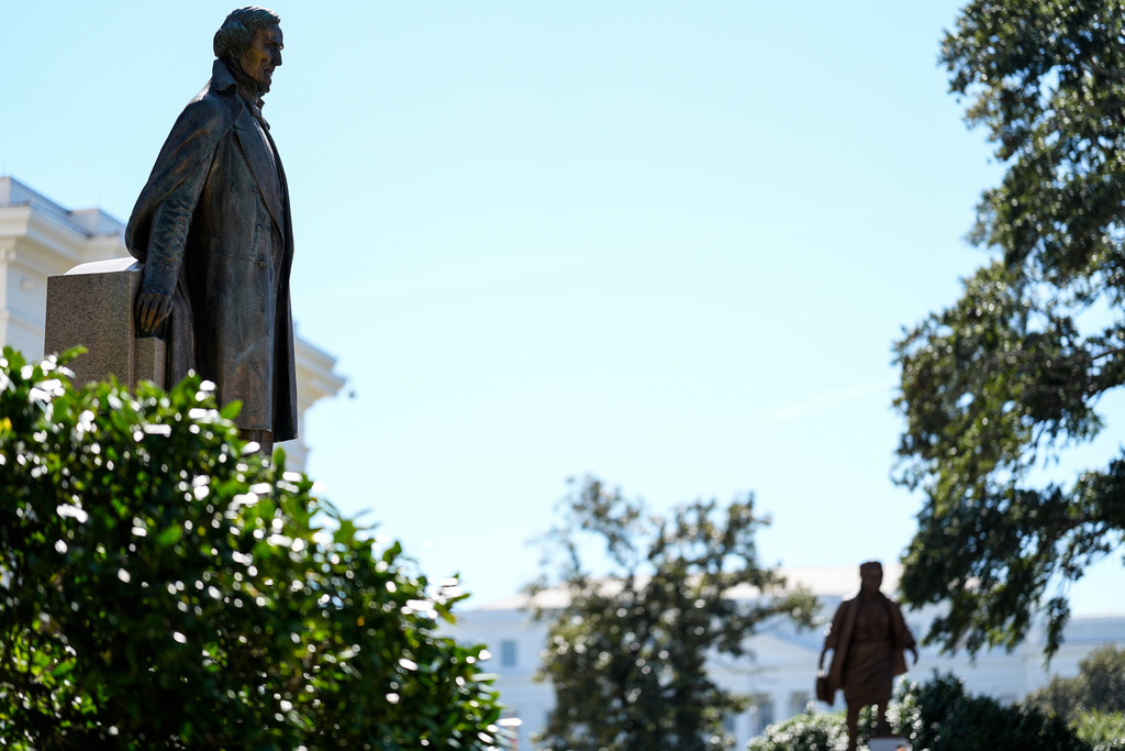 A statue of president of the Confederate States Jefferson Davis, left, and the newly unveiled statue of Rosa Parks are seen on the grounds of the Alabama State Capitol, Friday, Oct. 24, 2025, in Montgomery, Ala. (AP Photo/Mike Stewart)