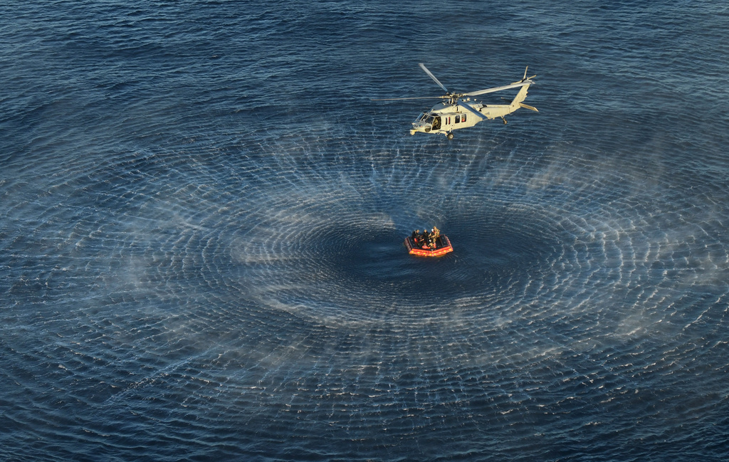 This photo provided by NASA shows the Artemis II crew being hoisted into a U.S. Navy MH-60 helicopter after successfully splashing down in the Pacific Ocean on Friday, April 10, 2026, following their 10-day mission around the Moon. (James Blair/NASA via AP)