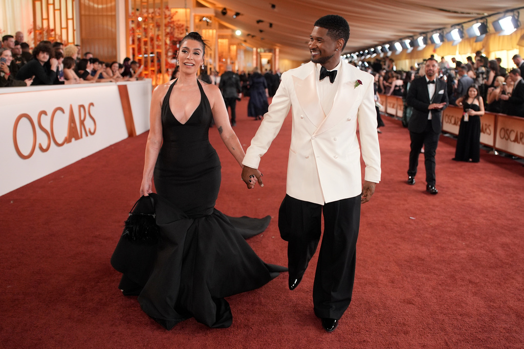 Jenn Goicoechea, left, and Usher arrives at the Oscars on Sunday, March 15, 2026, at the Dolby Theatre in Los Angeles. (AP Photo/John Locher)