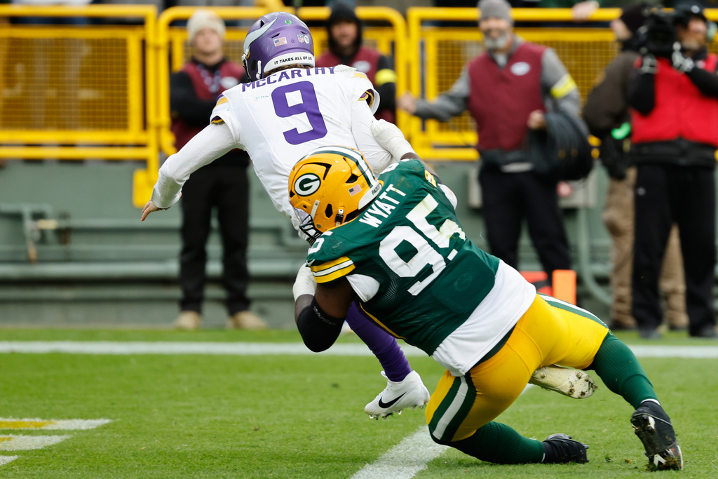 Minnesota Vikings quarterback J.J. McCarthy (9) is sacked by Green Bay Packers defensive tackle Devonte Wyatt (95) during the second half of an NFL football game Sunday, Nov. 23, 2025, in Green Bay, Wis. (AP Photo/Mike Roemer)