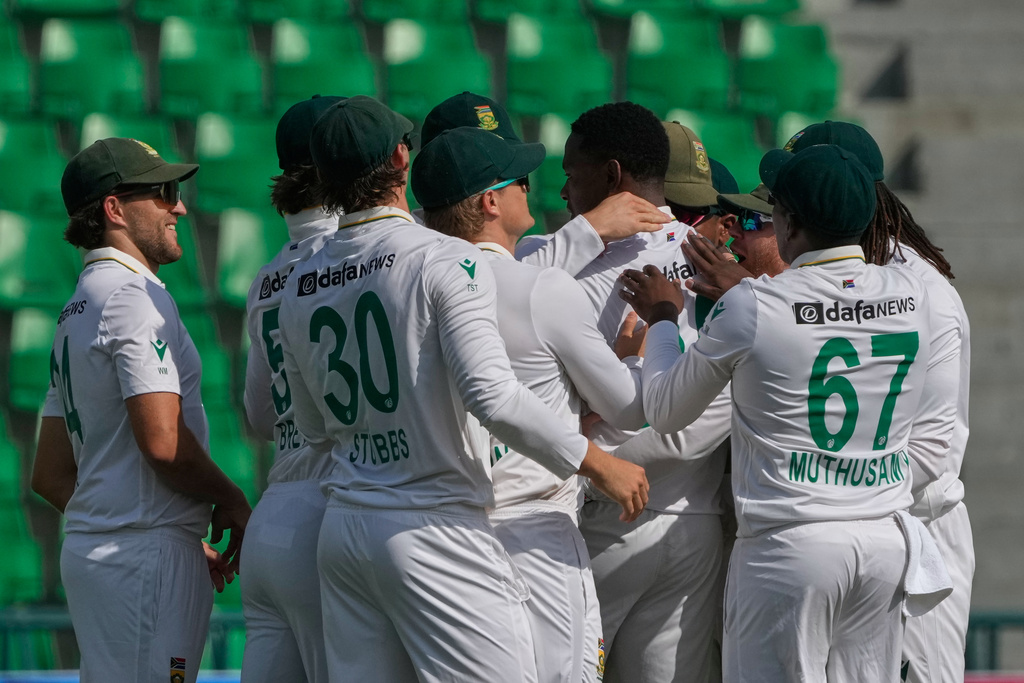 South Africa's Kagiso Rabada, center, celebrates with teammates after taking the wicket of Pakistan's Abdullah Shafique during the first day of of first test cricket match between Pakistan and South Africa, in Lahore, Pakistan, Sunday, Oct. 12, 2025. (AP Photo/K.M. Chaudary)