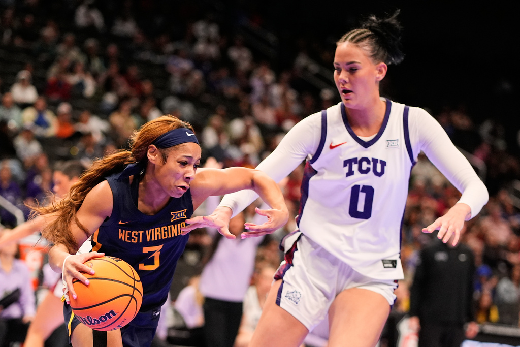 West Virginia guard Gia Cooke (3) drives past TCU center Kennedy Basham (0) during first half of the NCAA college basketball championship game at the Big 12 Conference tournament Sunday, March 8, 2026, in Kansas City, Mo. (AP Photo/Charlie Riedel)