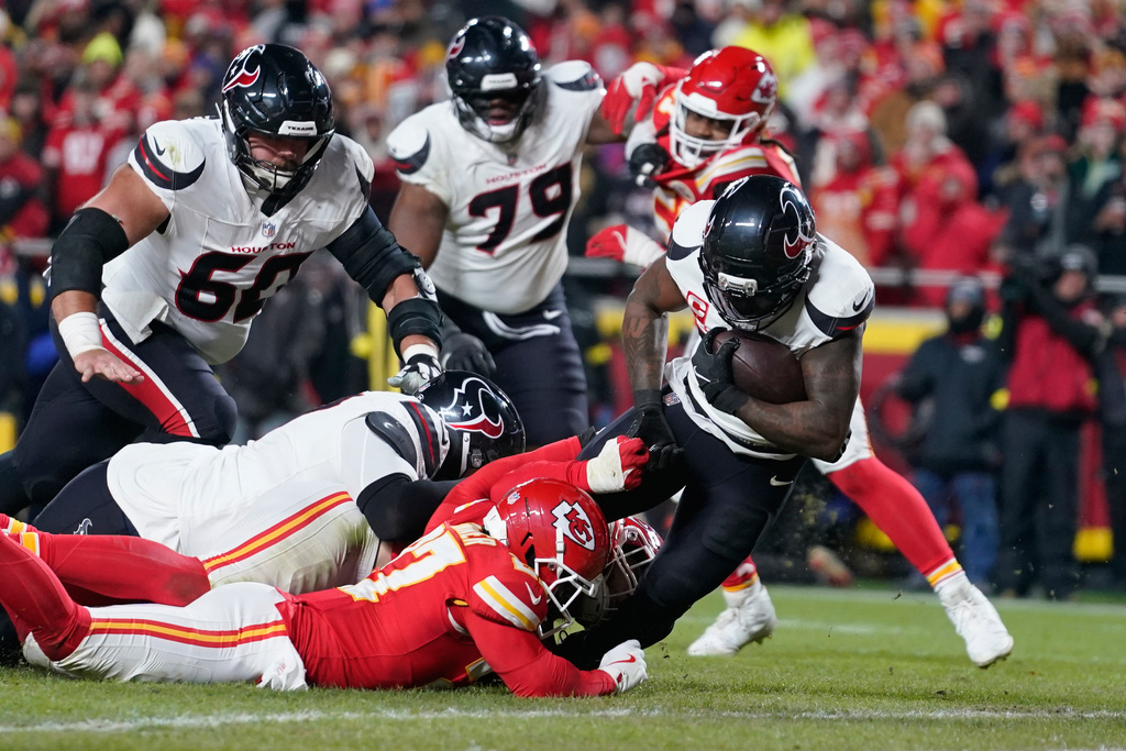 Houston Texans running back Dare Ogunbowale, right, scores past Kansas City Chiefs defensive back Chamarri Conner during the second half of an NFL football game Wednesday, Jan. 7, 2026, in Kansas City, Mo. (AP Photo/Ed Zurga)