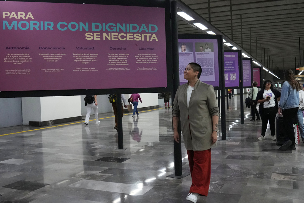 Samara Martínez, a supporter of a law to decriminalize euthanasia, stands next to the "Muerte Digna," or Dignified Death, exhibition at the Ermita metro station in Mexico City, Monday, March 23, 2026. (AP Photo/Marco Ugarte)
